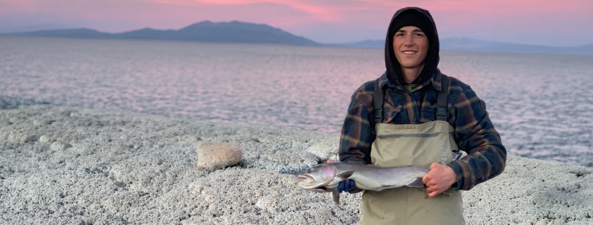 Hayden, founder and steward, holding a freshly caught fish at the Great Salt Lake